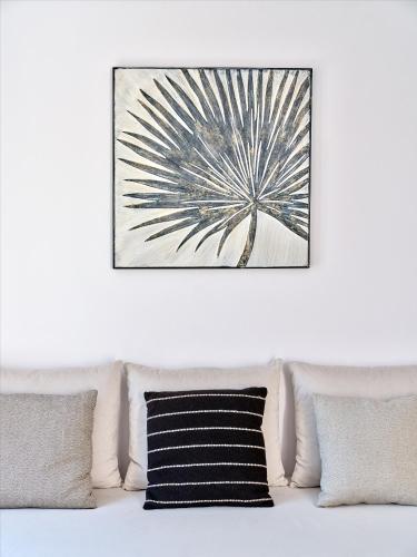a picture hanging above a couch with pillows at Paros Gem in Naousa