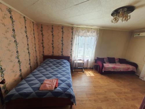 Un dormitorio con una cama y un sofá y una ventana. en Однокімнатні Апартаменти повністю, en Krivoy Rog