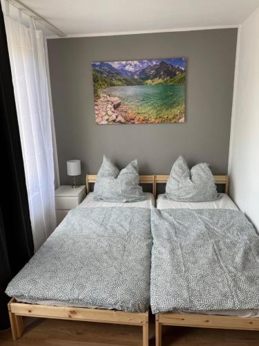 a bedroom with two beds and a painting on the wall at Modernes Appartement "Tom" mit 3 Schlafzimmern in Kröllwitz
