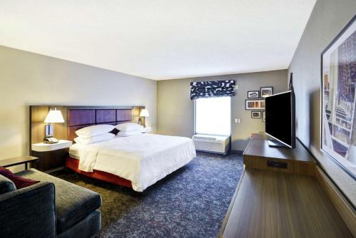 a hotel room with a bed and a flat screen tv at Hampton Inn & Suites Columbus-Easton Area in Columbus