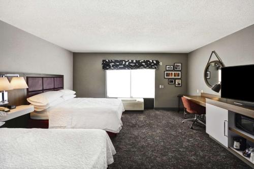 a hotel room with two beds and a desk and a window at Hampton Inn & Suites Columbus-Easton Area in Columbus
