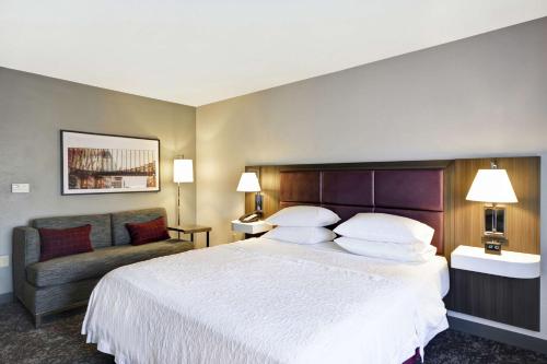 a hotel room with a large bed and a couch at Hampton Inn & Suites Columbus-Easton Area in Columbus
