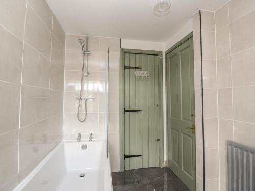 een badkamer met een wit bad en een douche bij 2 Fleet Street in Castle Douglas