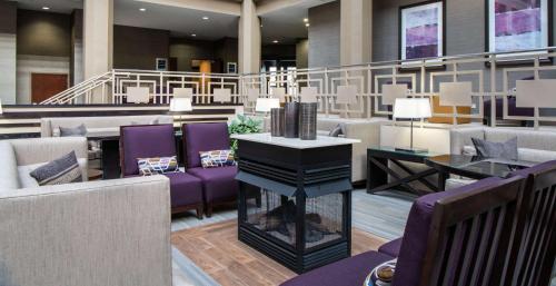 a lobby with purple chairs and a piano at Embassy Suites by Hilton Chicago North Shore Deerfield in Deerfield