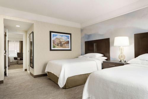 a hotel room with two beds and a bathroom at Embassy Suites by Hilton Chicago North Shore Deerfield in Deerfield