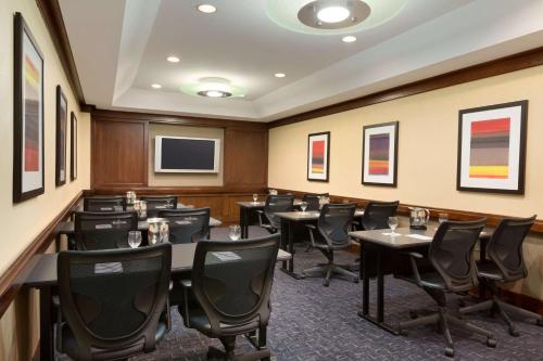 a conference room with tables and chairs and a tv at Embassy Suites by Hilton Chicago North Shore Deerfield in Deerfield