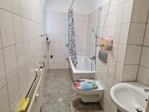 e bagno con servizi igienici, lavandino e vasca. di Unterkunft an der Karl-Marx Straße Leipzig a Lipsia