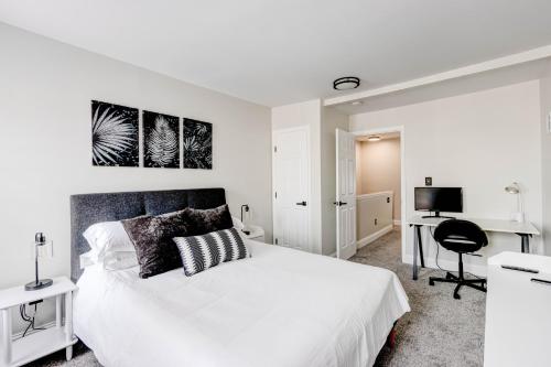 a white bedroom with a bed and a desk at Elegant Urban Retreat - Walk To Patterson Park in Baltimore