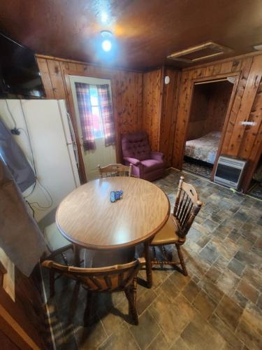 a room with a table and a couch and a bed at cabin 2 in Manistique
