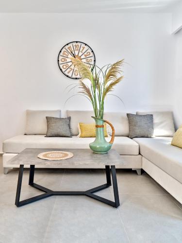 a living room with a couch and a table with a vase at Paros Gem in Naousa