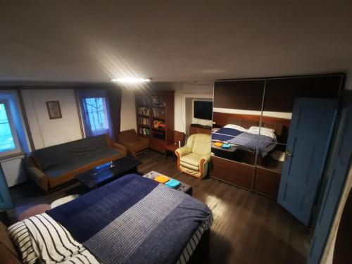 a small bedroom with a bed and a chair at Pasja Grofica in Idrija