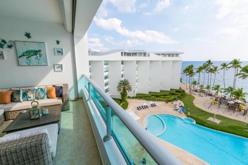 a view of the pool from the balcony of a resort at Marbella Juan Dolio Beachfront in Juan Dolio