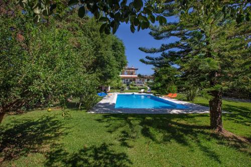 a swimming pool in a yard with trees at KORALIA MARATHON VILLA in Nea Makri