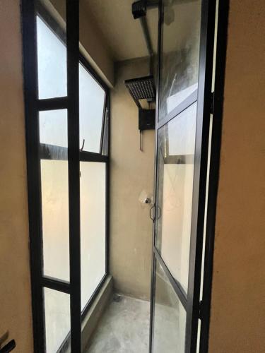 uma porta de duche em vidro num quarto com uma janela em Monkey Lodge - Casa na Mata no Rio de Janeiro