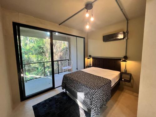 a bedroom with a bed and a large window at Monkey Lodge - Casa na Mata in Rio de Janeiro