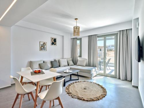 a living room with a couch and a table and chairs at Paros Gem in Naousa