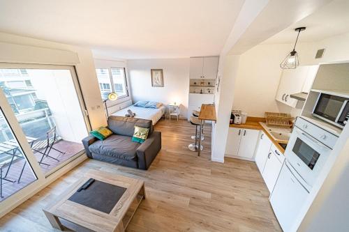 ein Wohnzimmer mit einem Sofa und einer Küche in der Unterkunft Le petit Massena-cosy 2 pers balcon- Part Dieu in Lyon