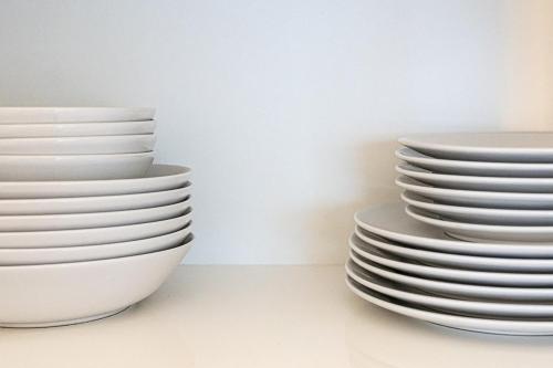 a stack of white plates sitting on a wall at Le petit Massena-cosy 2 pers balcon- Part Dieu in Lyon