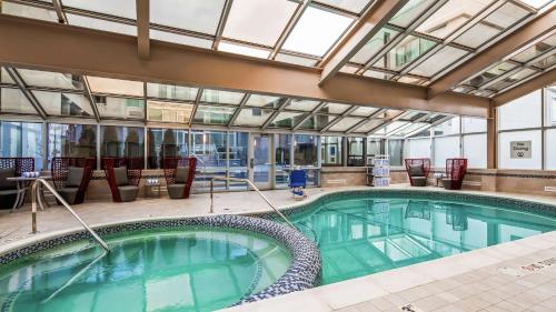 een groot zwembad met stoelen en een binnenzwembad bij The Kingsley Bloomfield Hills - a DoubleTree by Hilton in Bloomfield Hills