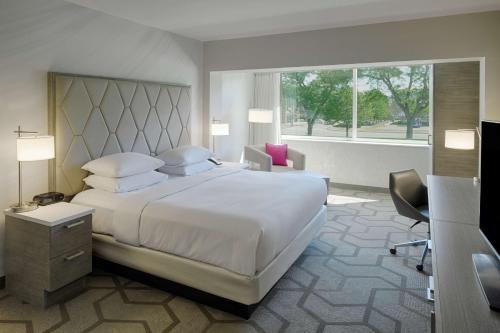 The Kingsley Bloomfield Hills - a DoubleTree by Hilton في بلومفيلد هيلز: غرفة نوم بسرير ابيض كبير ونافذة
