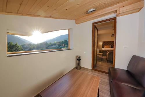 a living room with a couch and a window at Chalet Kujta in Peje