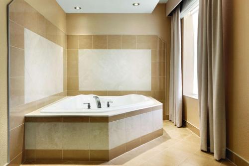 a bathroom with a bath tub and a sink at Hilton Garden Inn Niagara-on-the-Lake in Niagara-on-the-Lake
