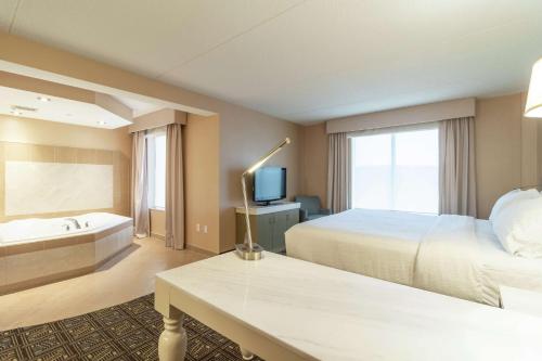 a hotel room with a bed and a bath tub at Hilton Garden Inn Niagara-on-the-Lake in Niagara on the Lake