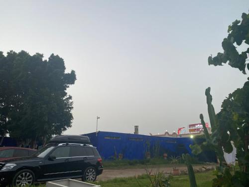 タンジェにあるCabano beachの青い壁の駐車場に停めた黒車