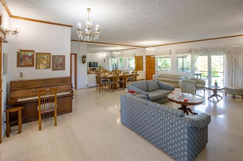 a living room with a couch and a piano at KORALIA MARATHON VILLA in Nea Makri