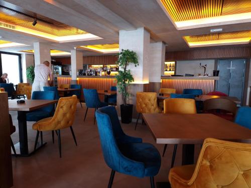 um restaurante com mesas de madeira e cadeiras azuis em Milmari P79 em Kopaonik