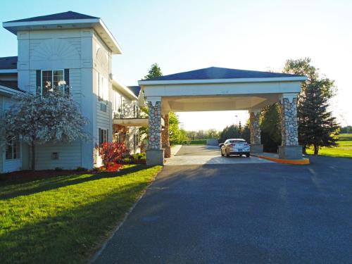a car parked under a garage in front of a house at American Inn and Suites Houghton Lake in Houghton Lake