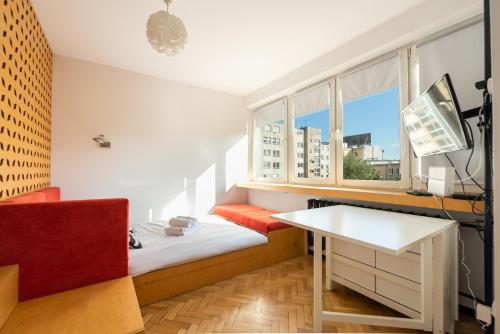 a small room with a bed and a desk and a window at Spiska Standard Studio in Warsaw