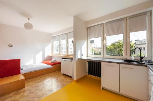 a kitchen with white cabinets and a yellow floor at Spiska Standard Studio in Warsaw