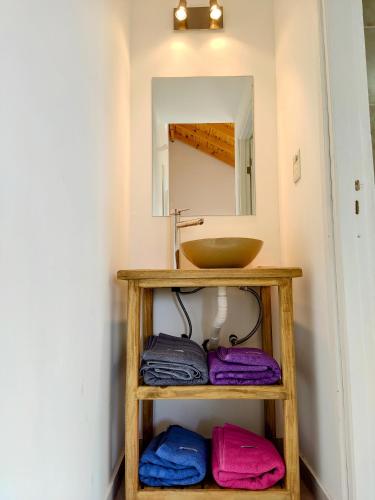 a bathroom with a sink and towels on a shelf at Cabaña Maca Tobiano in El Calafate