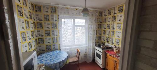a small kitchen with a table and a window at Квартира на Бульварі Вечірньому in Kryvyi Rih