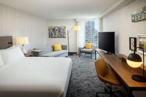 a hotel room with a bed and a desk at The Bethesdan Hotel, Tapestry Collection by Hilton in Bethesda