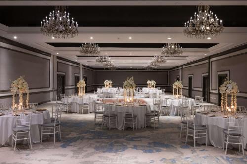 a ballroom with white tables and chairs and chandeliers at The Bethesdan Hotel, Tapestry Collection by Hilton in Bethesda