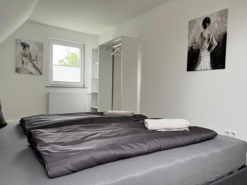 a large bed in a bedroom with two pictures on the wall at Domo Dolce Wohnapartment in Appel