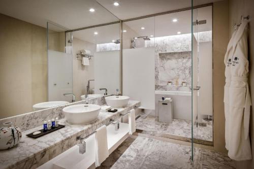 a bathroom with two sinks and a shower at Sheraton Baku Intourist in Baku