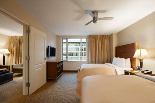 a hotel room with two beds and a television at Homewood Suites by Hilton Baltimore in Baltimore