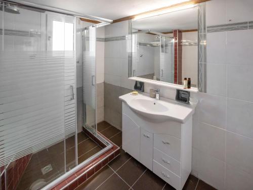 a white bathroom with a sink and a shower at KORALIA MARATHON VILLA in Nea Makri