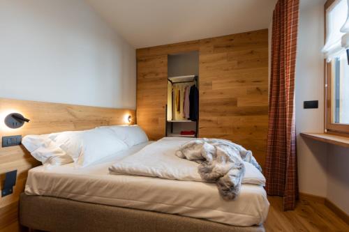 a dog laying on a bed in a bedroom at Maison Luboz - Courmayeur in Courmayeur