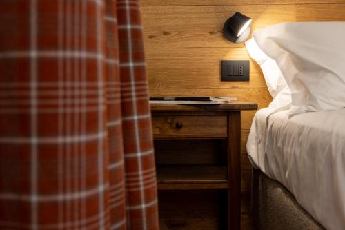 a bedroom with a bed and a nightstand with a lamp at Maison Luboz - Courmayeur in Courmayeur