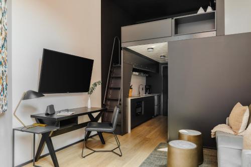 a living room with a desk and a tv and a kitchen at Sonder RailSpur in Seattle