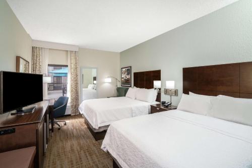 a hotel room with two beds and a flat screen tv at Hampton Inn & Suites Nashville Franklin in Franklin