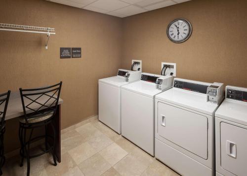 a room with three washing machines and a clock on the wall at Hampton Inn & Suites Westford-Chelmsford in Westford