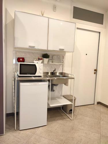a small kitchen with a sink and a microwave at Republic B&B in Bitonto
