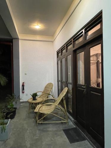 a patio with chairs and a table and a door at Shan Star Weligama in Weligama