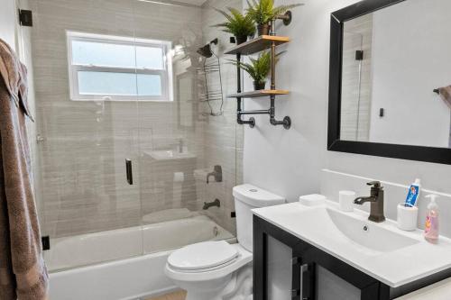 a bathroom with a toilet and a sink and a shower at Stadium Sunflower Miramar home, 3 bd, 2 ba in Miramar