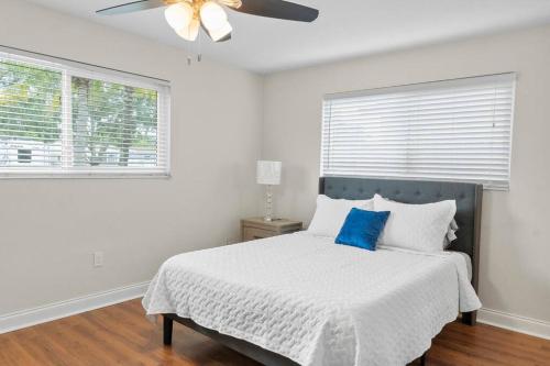 Dormitorio blanco con cama con almohada azul en Stadium Sunflower Miramar home, 3 bd, 2 ba, en Miramar